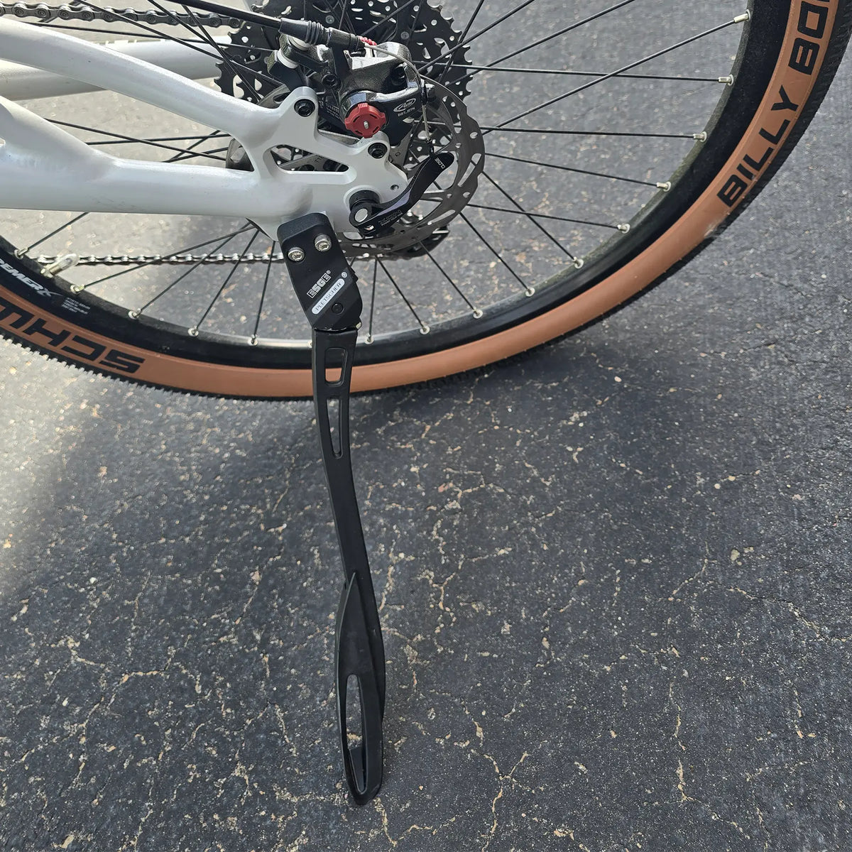 Closeup view of the kickstand and disc brake on the Azub Demo Six Bosch Performance CX Dynamic Grey Recumbent Bike in an outdoor setting.