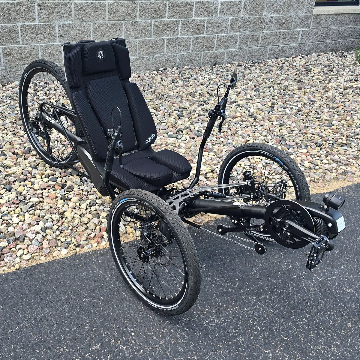Angled side view of the Azub Demo Ti-Fly 26 Shimano EP6 Deep Black Recumbent Trike in an outdoor setting.