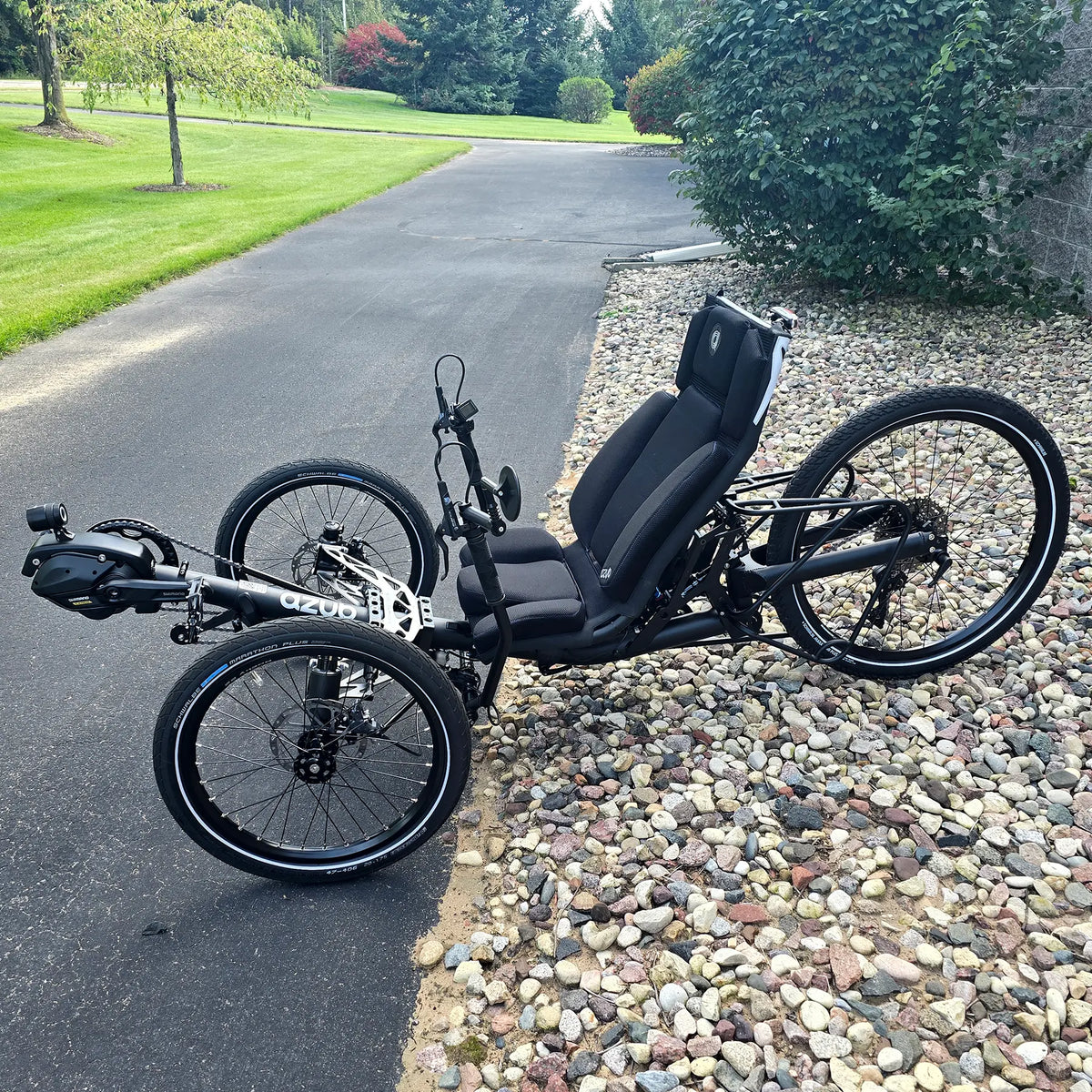 Non-drive side view of the Azub Demo Ti-Fly 26 Shimano EP6 Deep Black Recumbent Trike in an outdoor setting.
