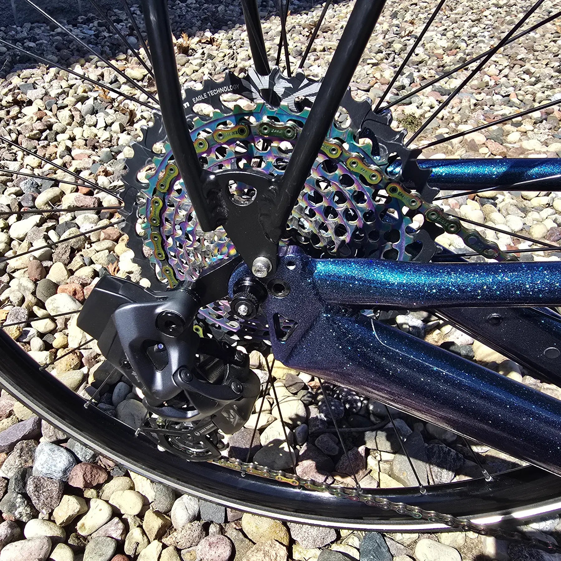 Closeup view of the rear drivetrain on the Azub Used T-Tris 5000 Chameleon Teal Custom Recumbent Trike in an outdoor setting.