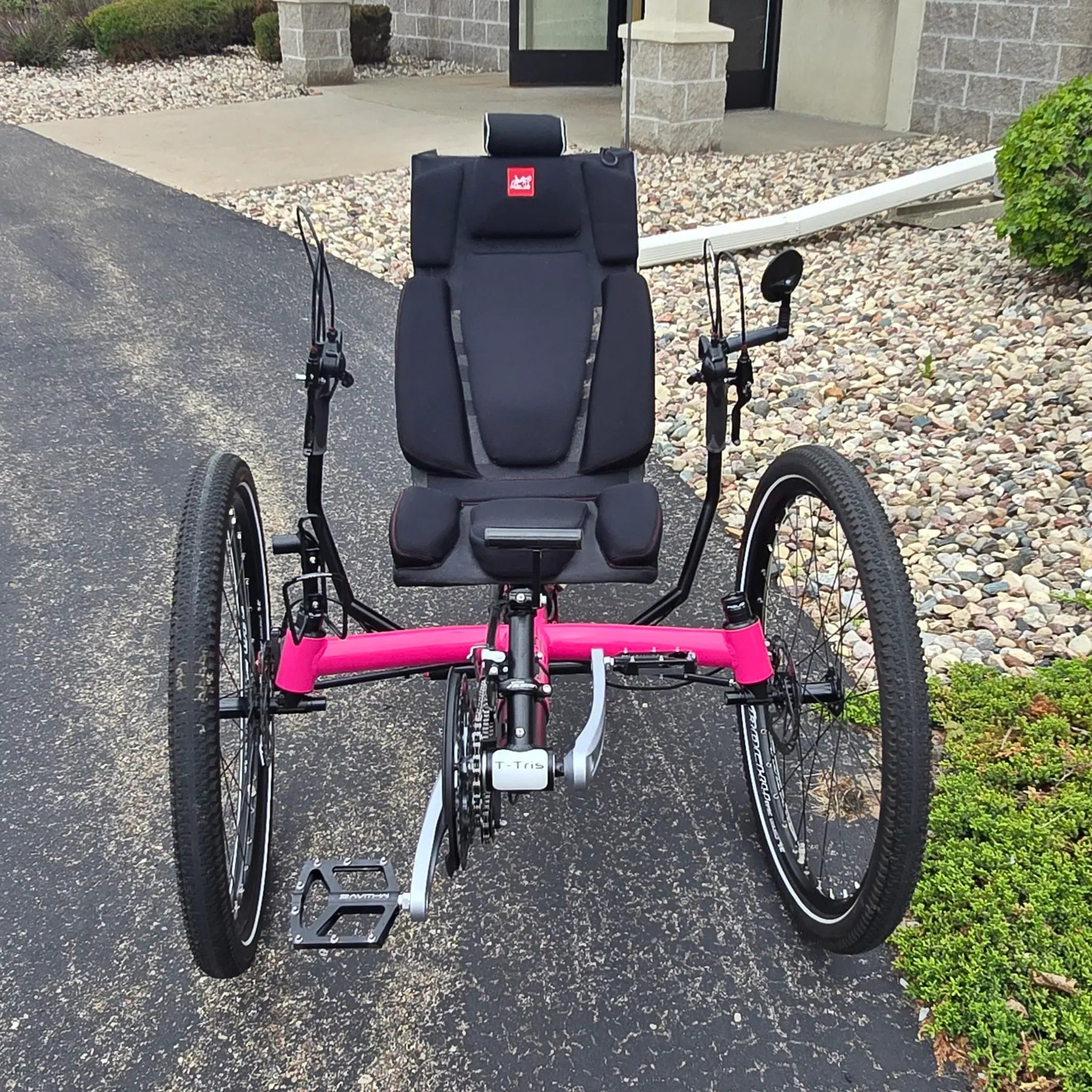 Front view of the Azub Used T-Tris AR Neon Pink Recumbent Trike in an outdoor setting.