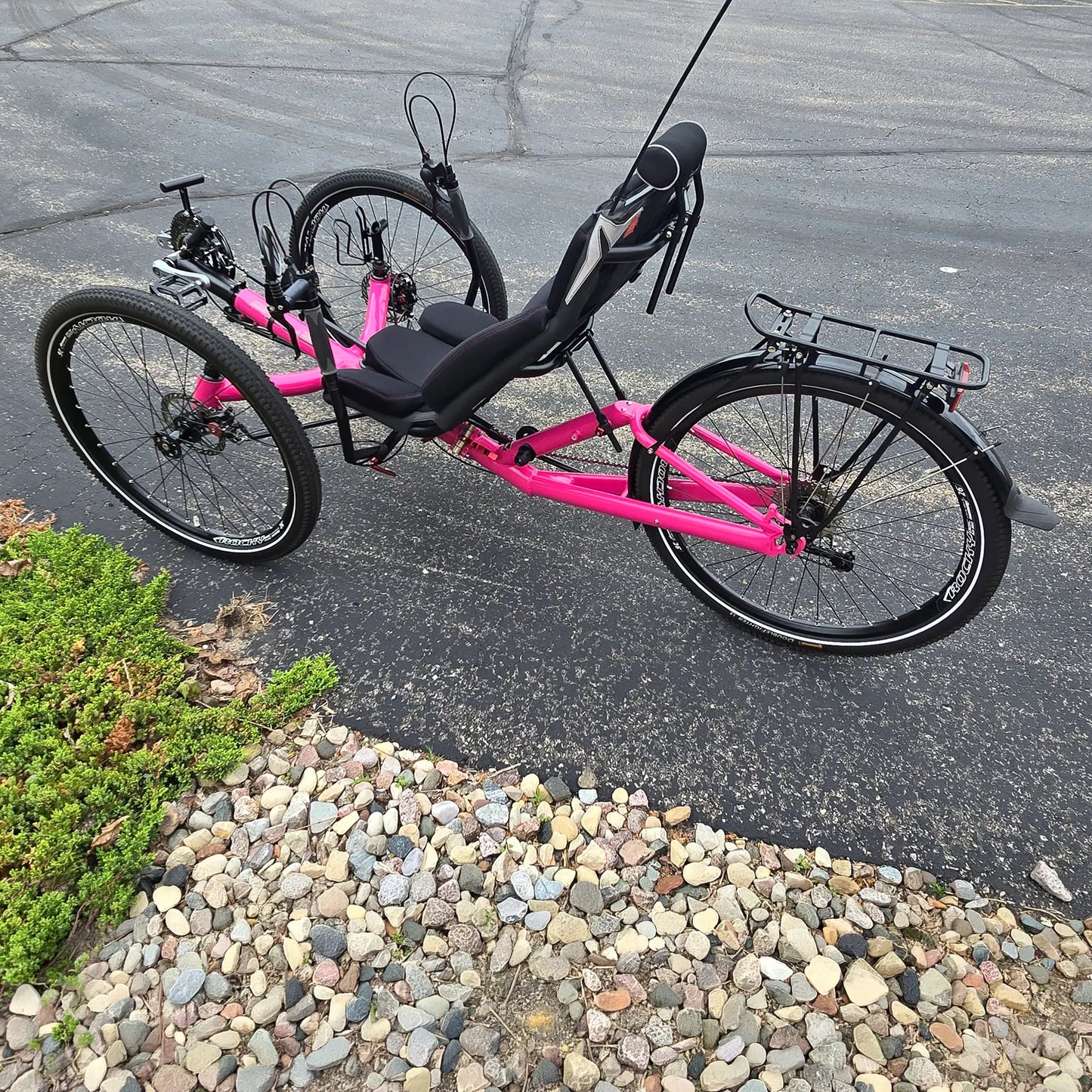 Non-drive side view of the Azub Used T-Tris AR Neon Pink Recumbent Trike in an outdoor setting.