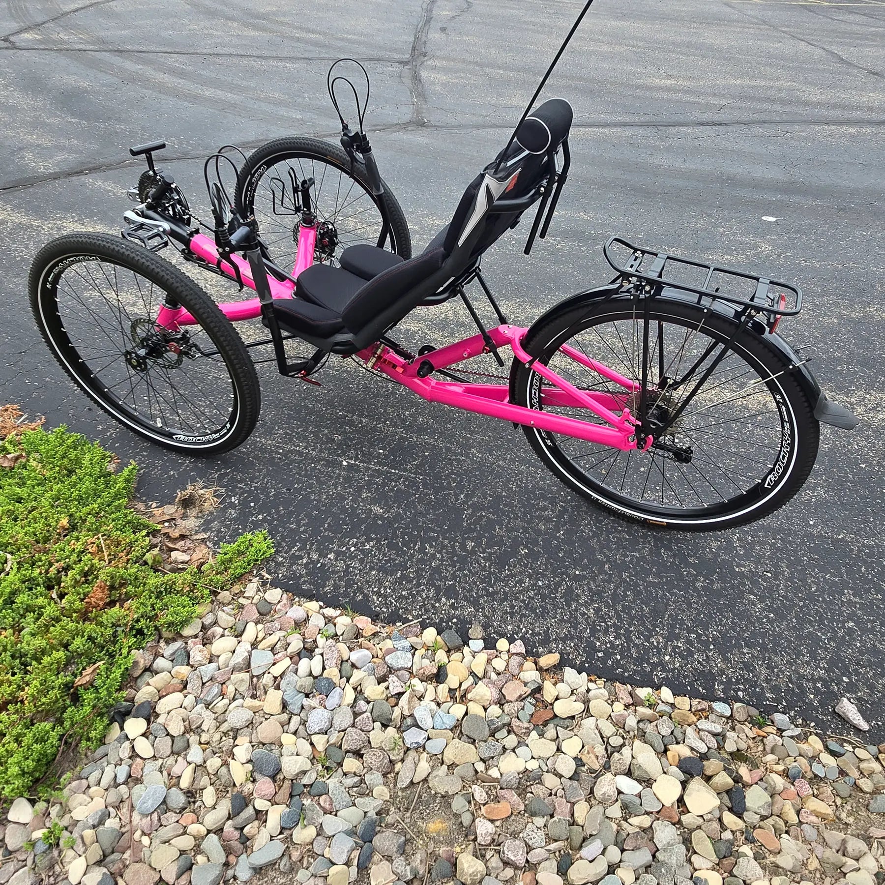 Non-drive side view of the Azub Used T-Tris AR Neon Pink Recumbent Trike in an outdoor setting.