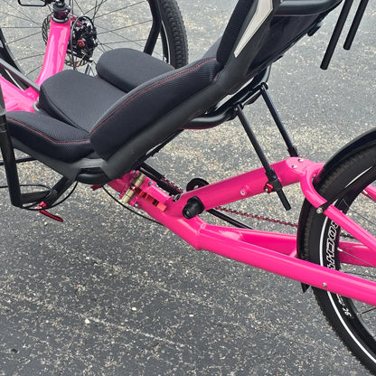 Closeup view of the folding hinge on the Azub Used T-Tris AR Neon Pink Recumbent Trike in an outdoor setting.