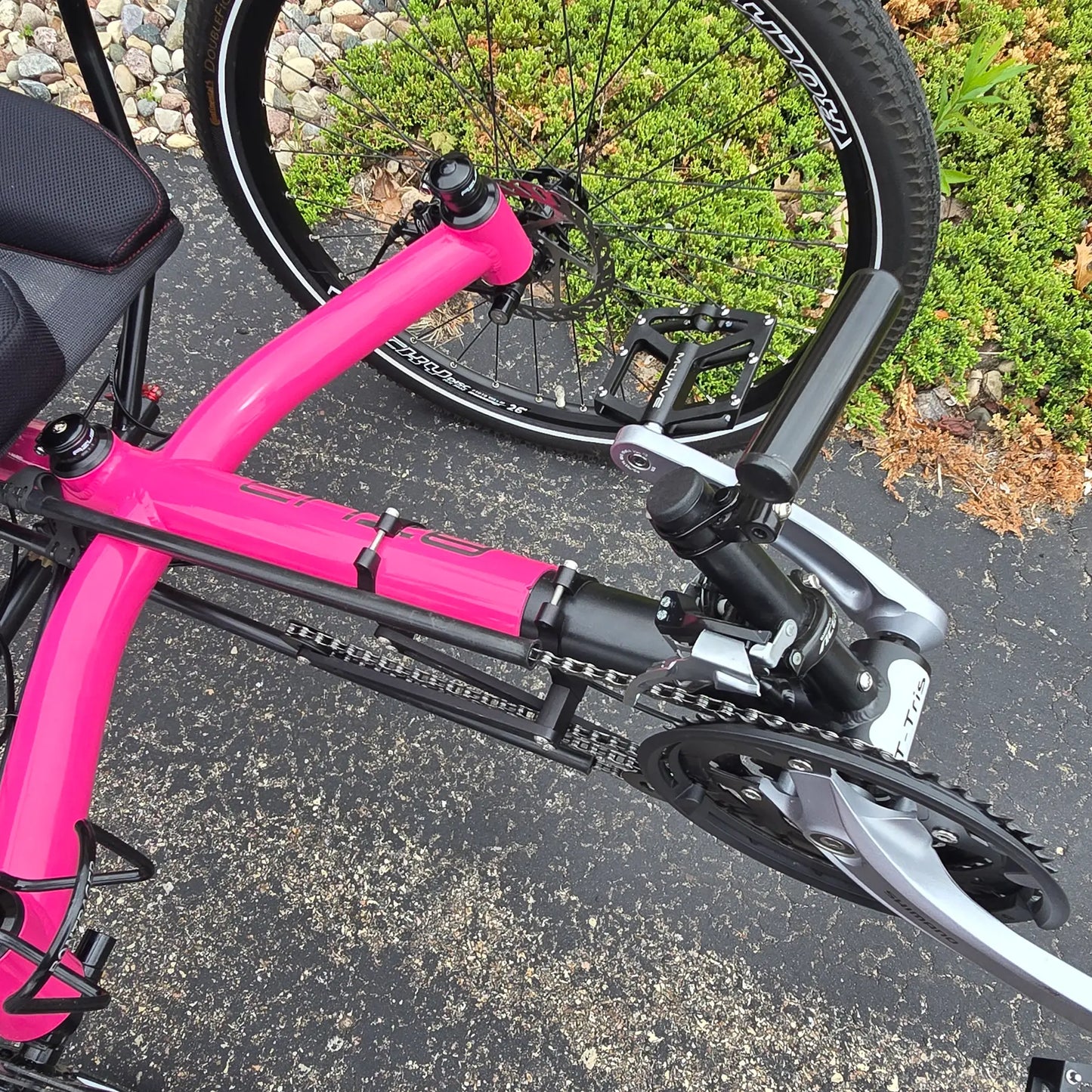 Closeup view of the light mount and quick adjust on the Azub Used T-Tris AR Neon Pink Recumbent Trike in an outdoor setting.