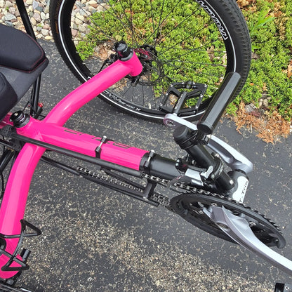 Closeup view of the light mount and quick adjust on the Azub Used T-Tris AR Neon Pink Recumbent Trike in an outdoor setting.