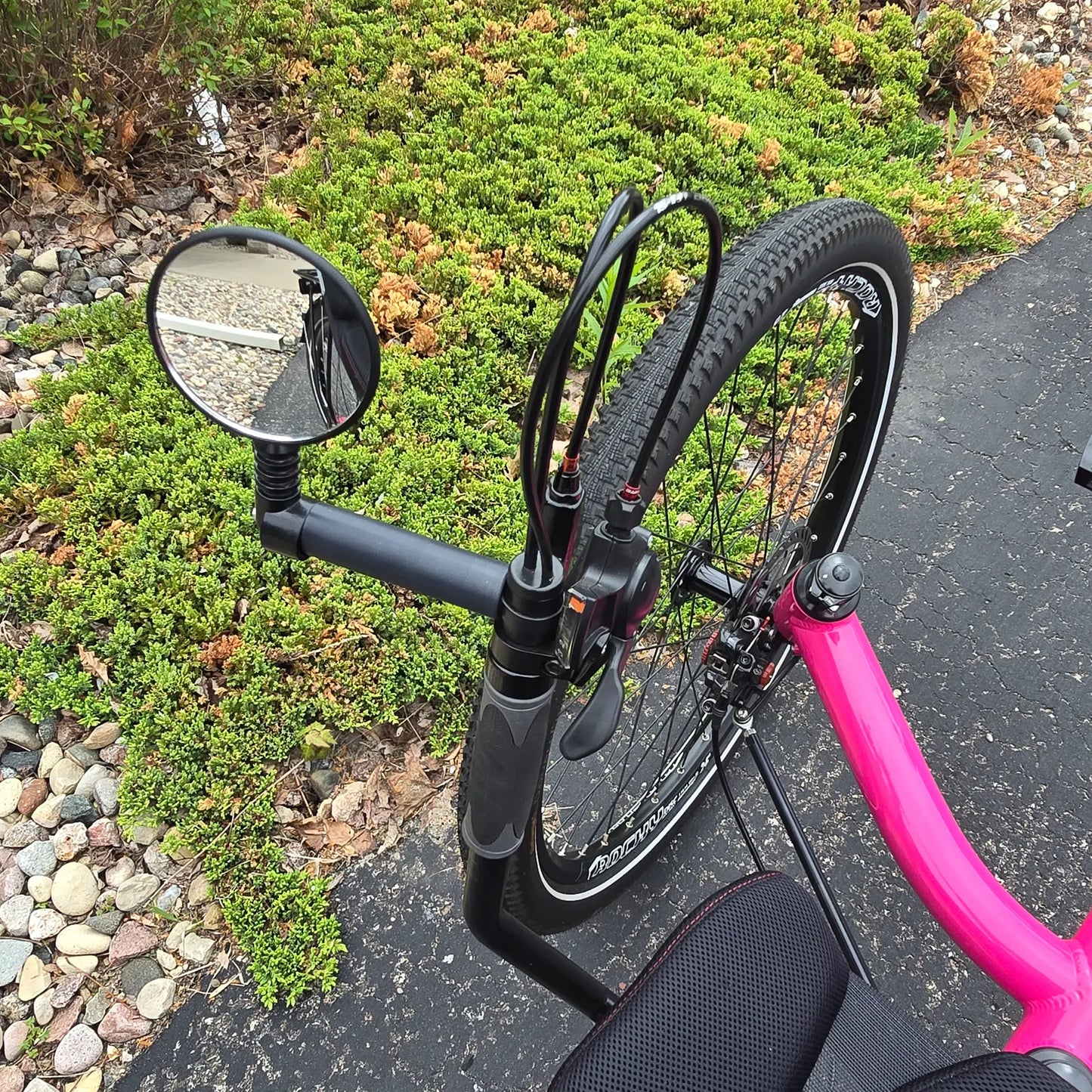 Closeup view of the accessory mount and mirror on the Azub Used T-Tris AR Neon Pink Recumbent Trike in an outdoor setting.