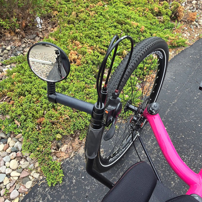Closeup view of the accessory mount and mirror on the Azub Used T-Tris AR Neon Pink Recumbent Trike in an outdoor setting.