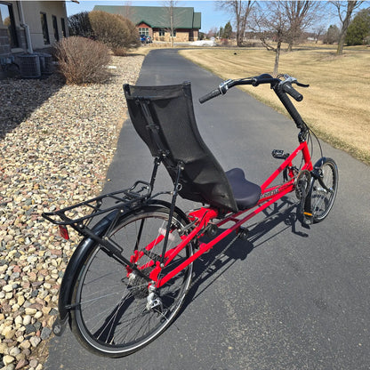 Angled rear view of the Bacchetta Used Bella Red SM-MD Recumbent Bike in an outdoor setting.