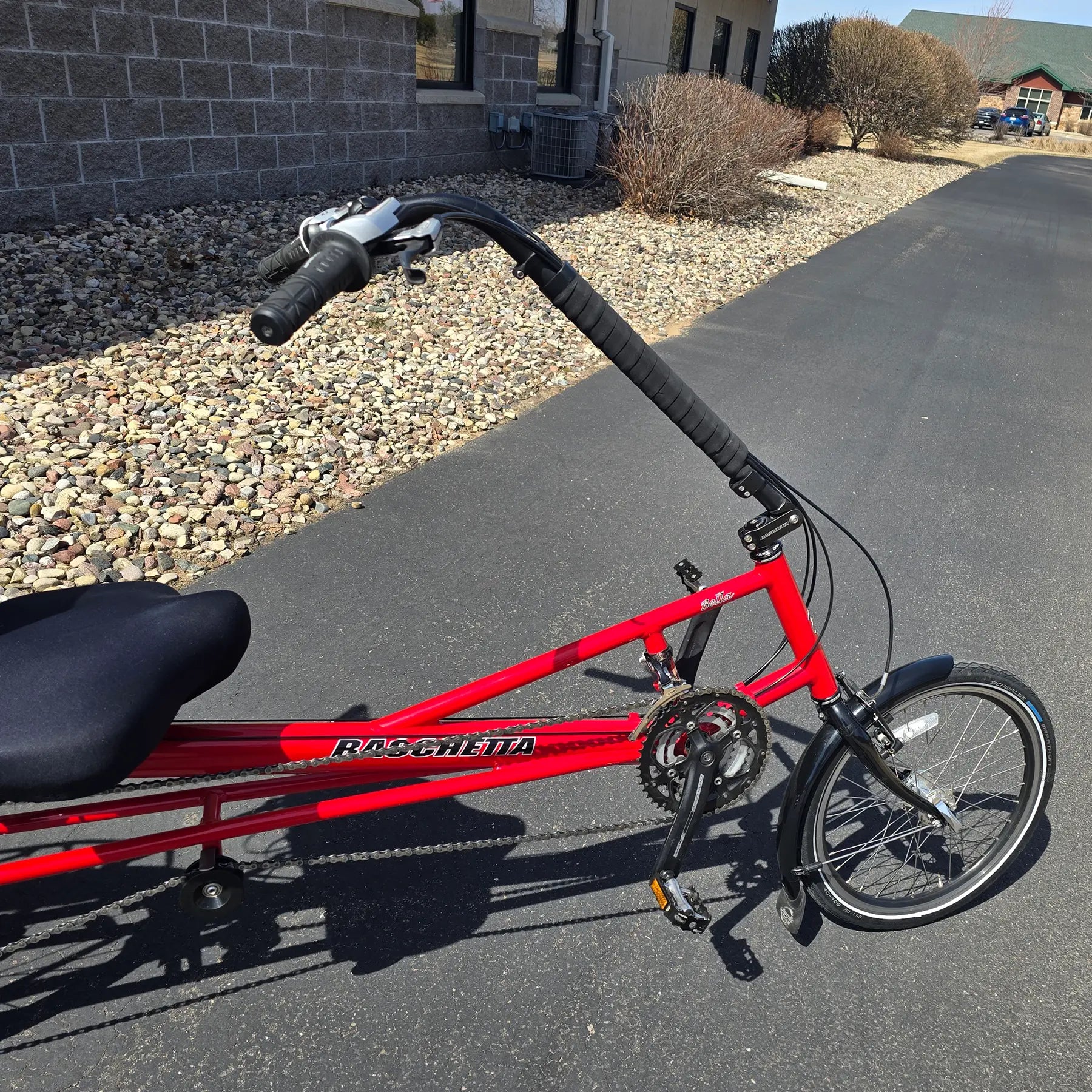 Closeup front view of the Bacchetta Used Bella Red SM-MD Recumbent Bike in an outdoor setting.