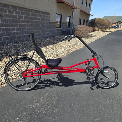Side view of the Bacchetta Used Bella Red SM-MD Recumbent Bike in an outdoor setting.