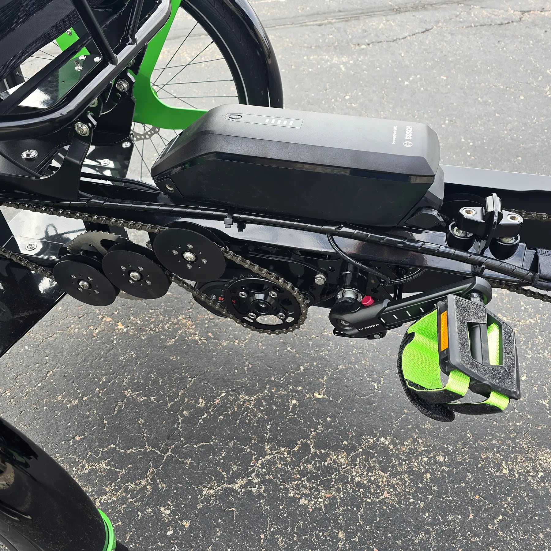 Closeup view of the left stoker crankset and drivetrain on the BamBuk Independent Bosch Performance CX Recumbent Tandem Trike in the Hostel Shoppe parking lot.