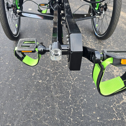 Closeup front view of the headlight and pedals on the BamBuk Independent Bosch Performance CX Recumbent Tandem Trike in the Hostel Shoppe parking lot.