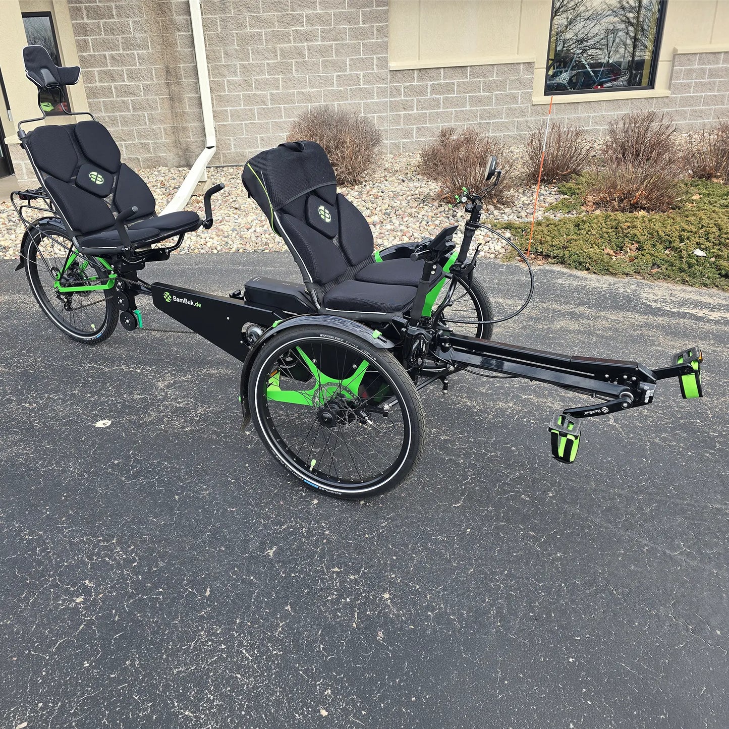 Angled side view of the BamBuk Independent Bosch Performance CX Recumbent Tandem Trike in the Hostel Shoppe parking lot.