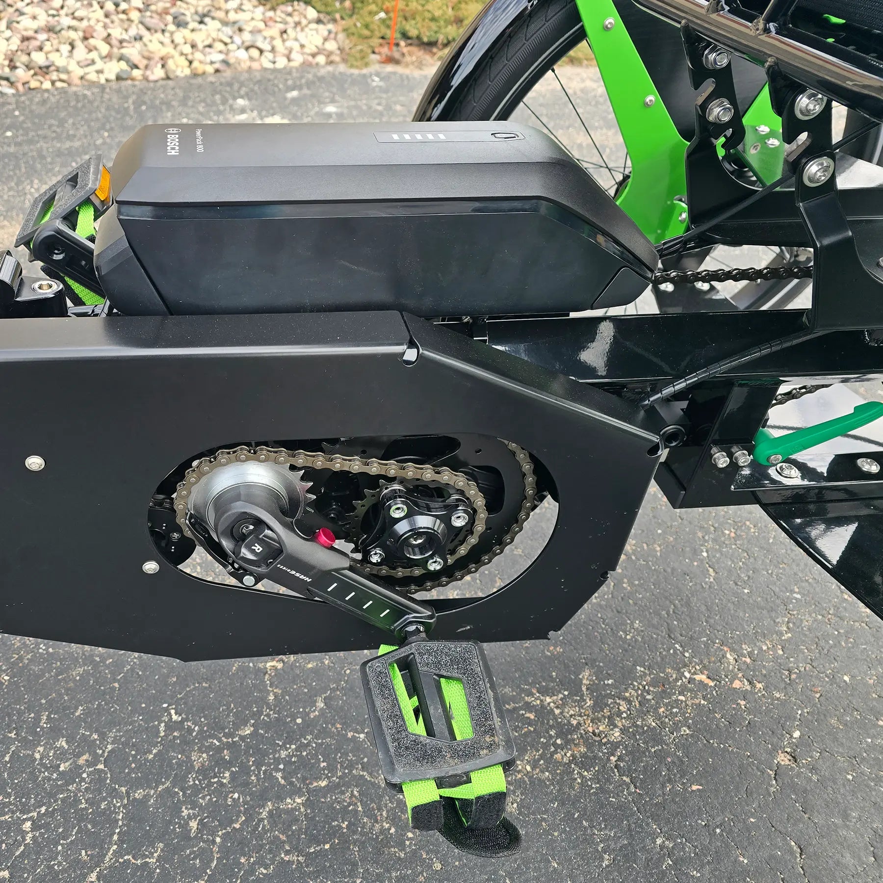 Closeup view of the rear crankset and battery on the BamBuk Independent Bosch Performance CX Recumbent Tandem Trike in the Hostel Shoppe parking lot.