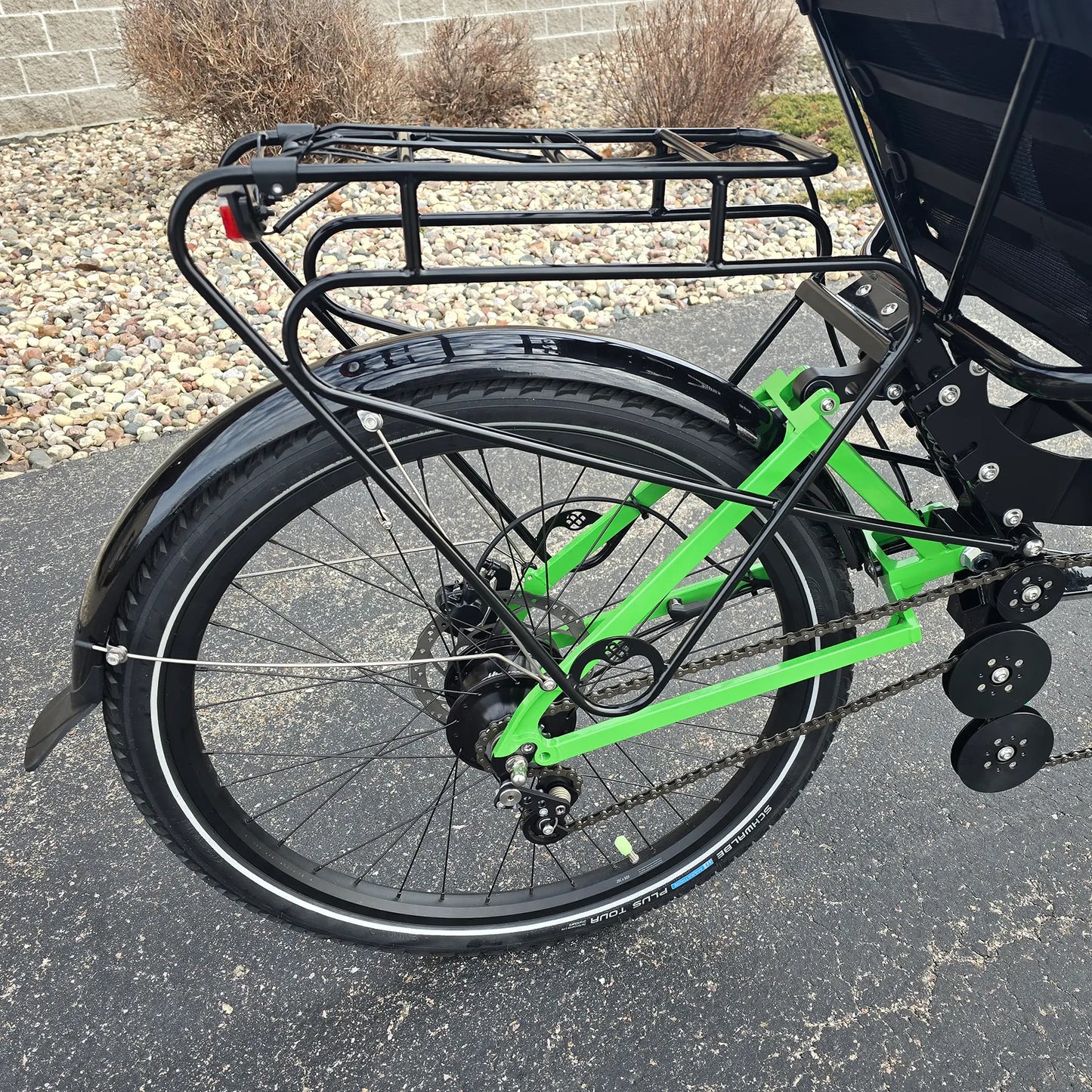 Closeup view of the rear rack and rear wheel on the BamBuk Independent Bosch Performance CX Recumbent Tandem Trike in the Hostel Shoppe parking lot.