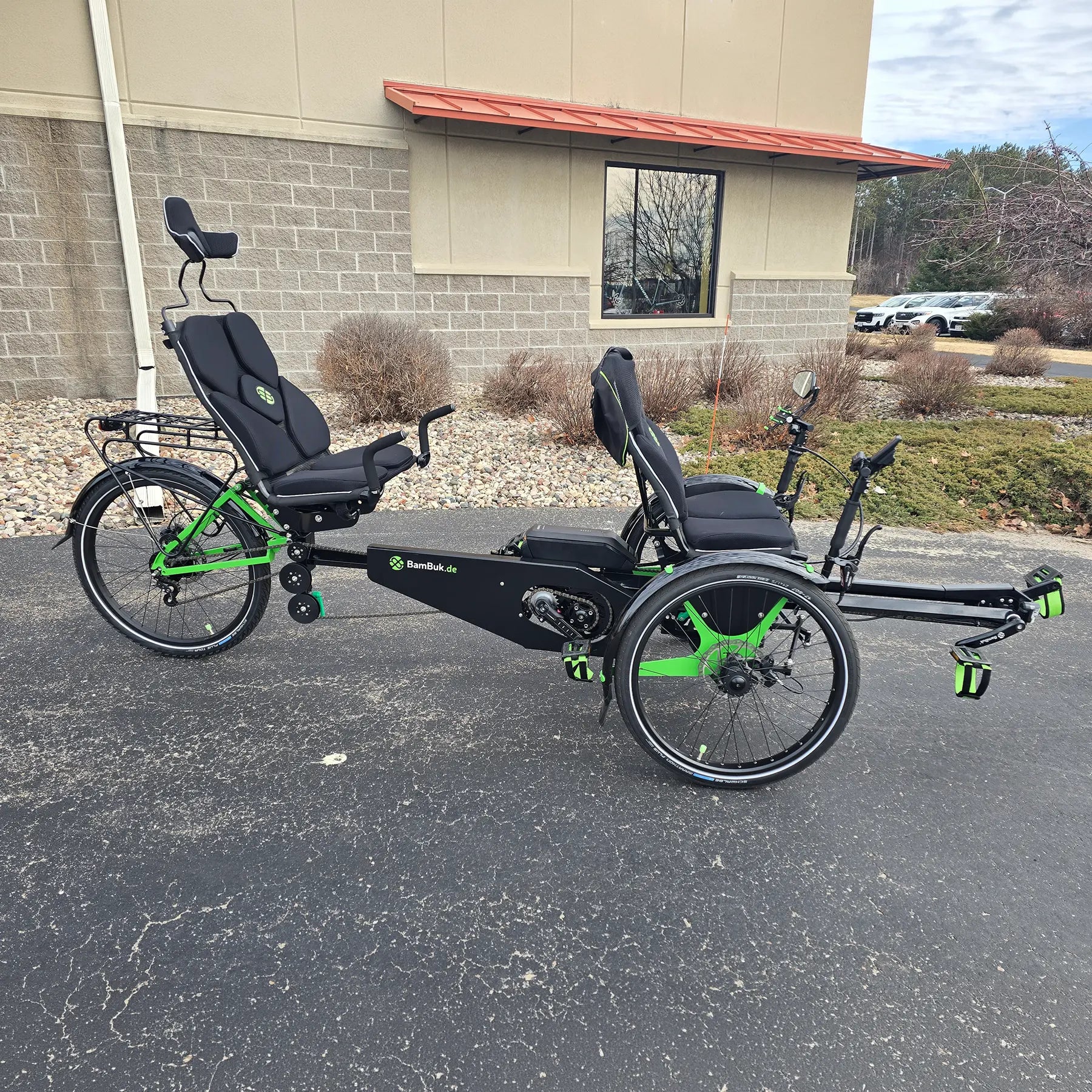 Side view of the BamBuk Independent Bosch Performance CX Recumbent Tandem Trike in the Hostel Shoppe parking lot.