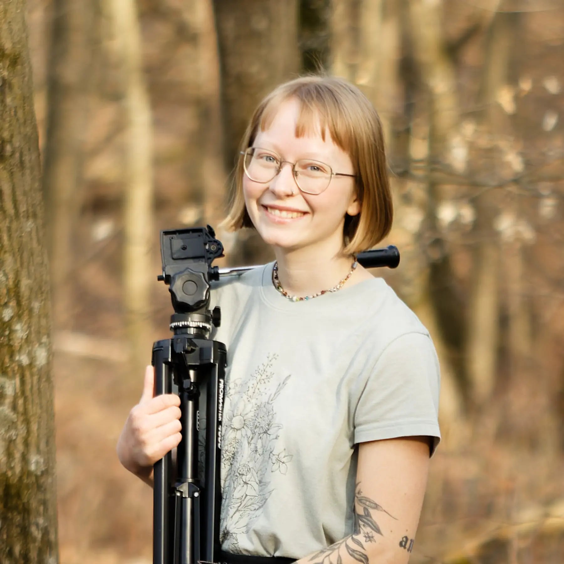 Brie, marketing Assistant in front of a wooded background.