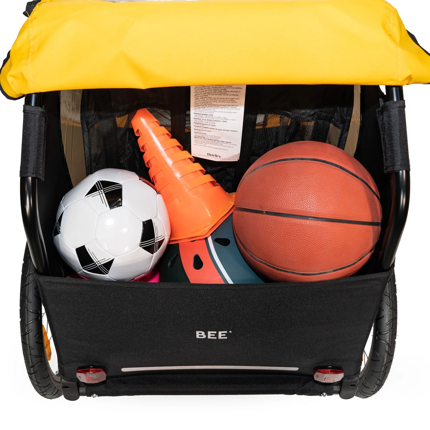 Rear detail view of the Burley Bee Double Child Trailer in Yellow, showing sporting goods items in the rear storage space, on a white background.