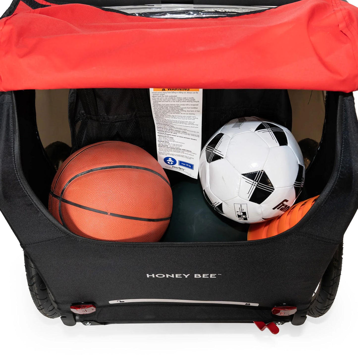 Rear detail view of the Burley Honey Bee Double Child Trailer in Red, showing sporting goods items in the rear storage space, on a white background.