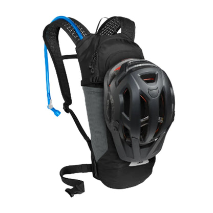 Angled front view of the Camelbak Lobo 9 Hydration Pack 70oz in black with a helmet attached to it against a white background.