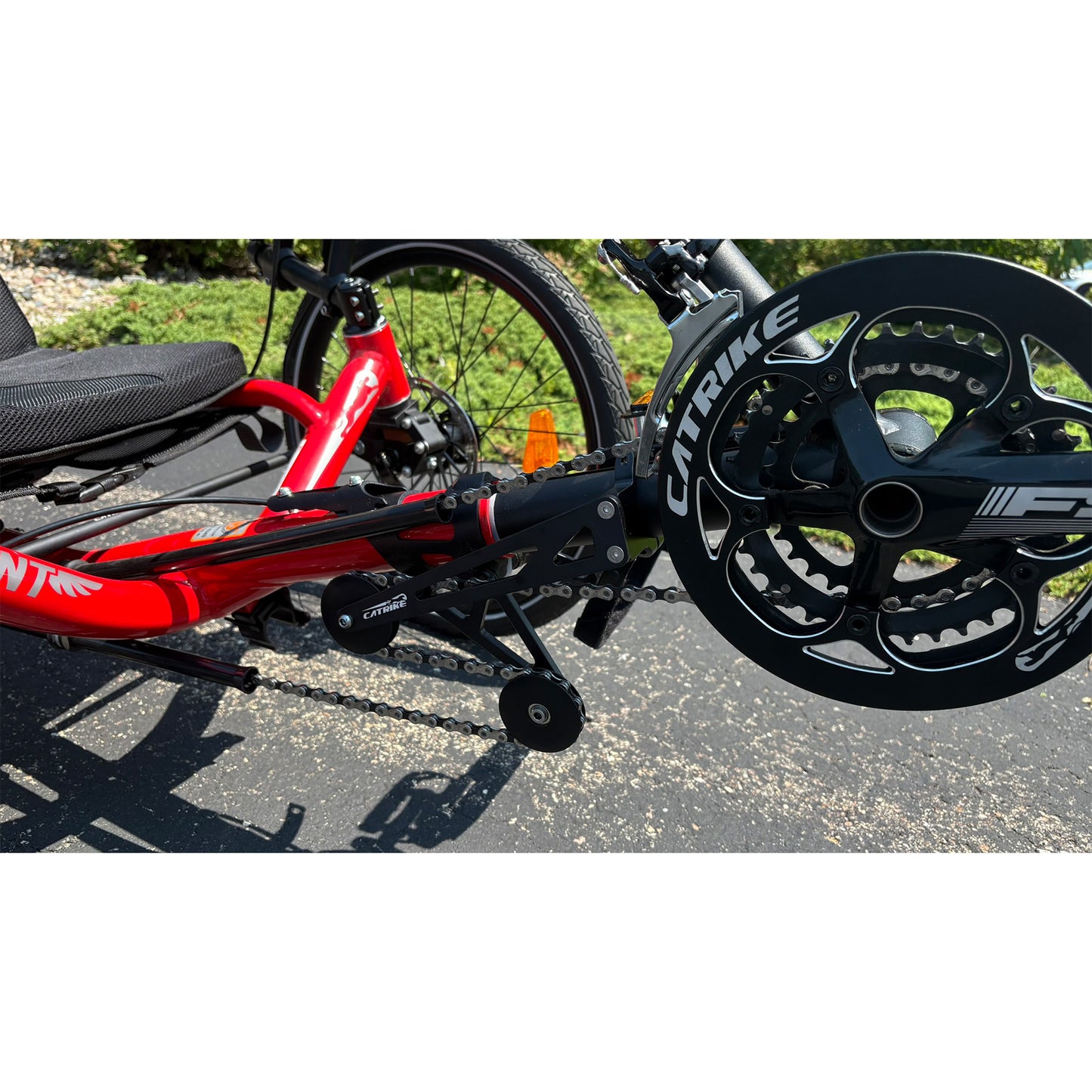 Closeup front view of a Demo Catrike Dumont in Lava Red in an outdoor setting.