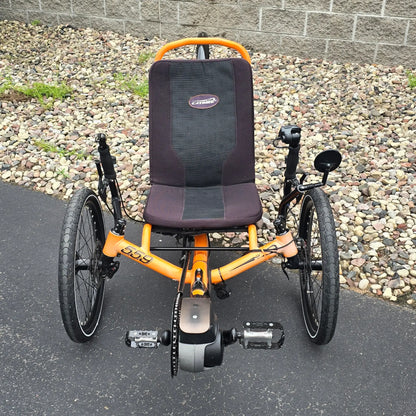 Front view of the Catrike Used 5.5.9. e-Cat Atomic Orange Recumbent Trike in an outdoor setting.