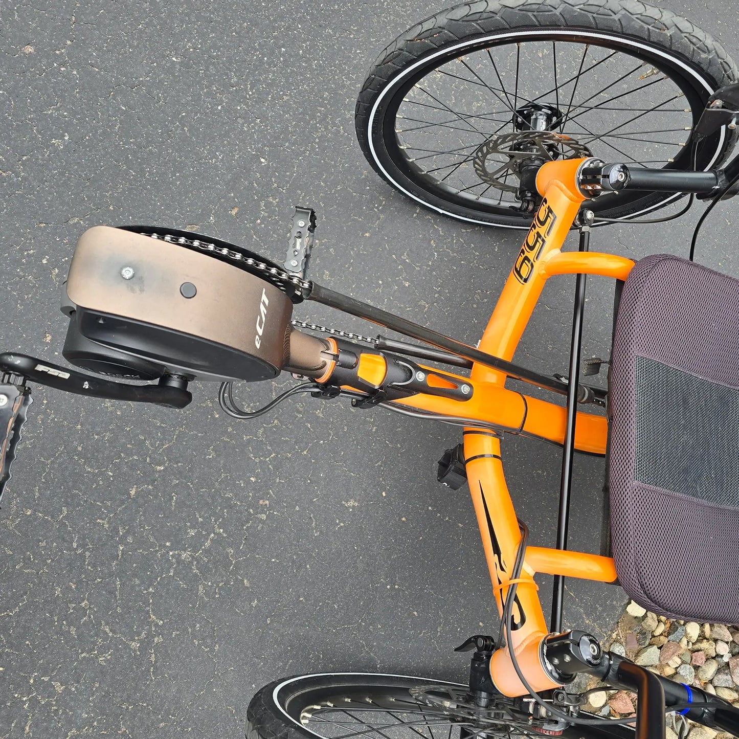 Overhead view of the Cat Atomic Orange Recumbent Trike showing sun fading in an outdoor setting.