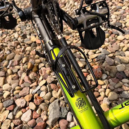 Closeup view of the bottle cage and pedals on the Catrike Used Pocket Eon Green Recumbent Trike in an outdoor setting.