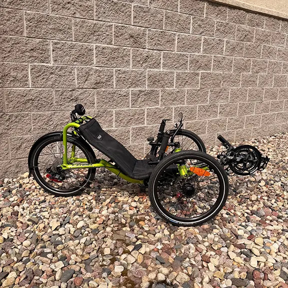 Side view of the Catrike Used Pocket Eon Green Recumbent Trike in an outdoor setting.