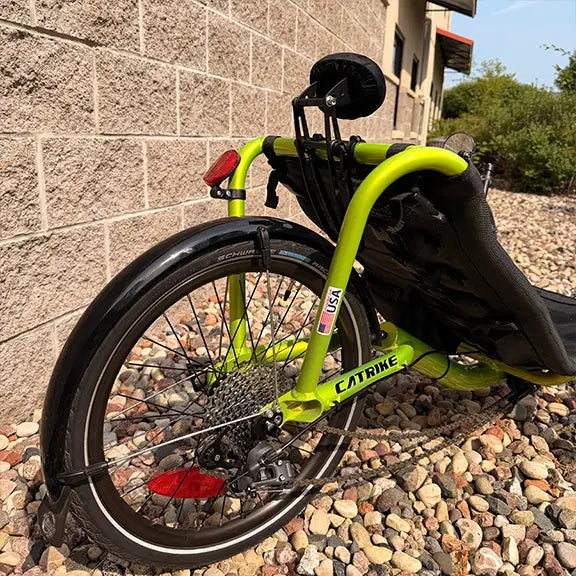 Closeup view of the neckrest, rear fender and wheel on the Catrike Used Pocket Eon Green Recumbent Trike in an outdoor setting.