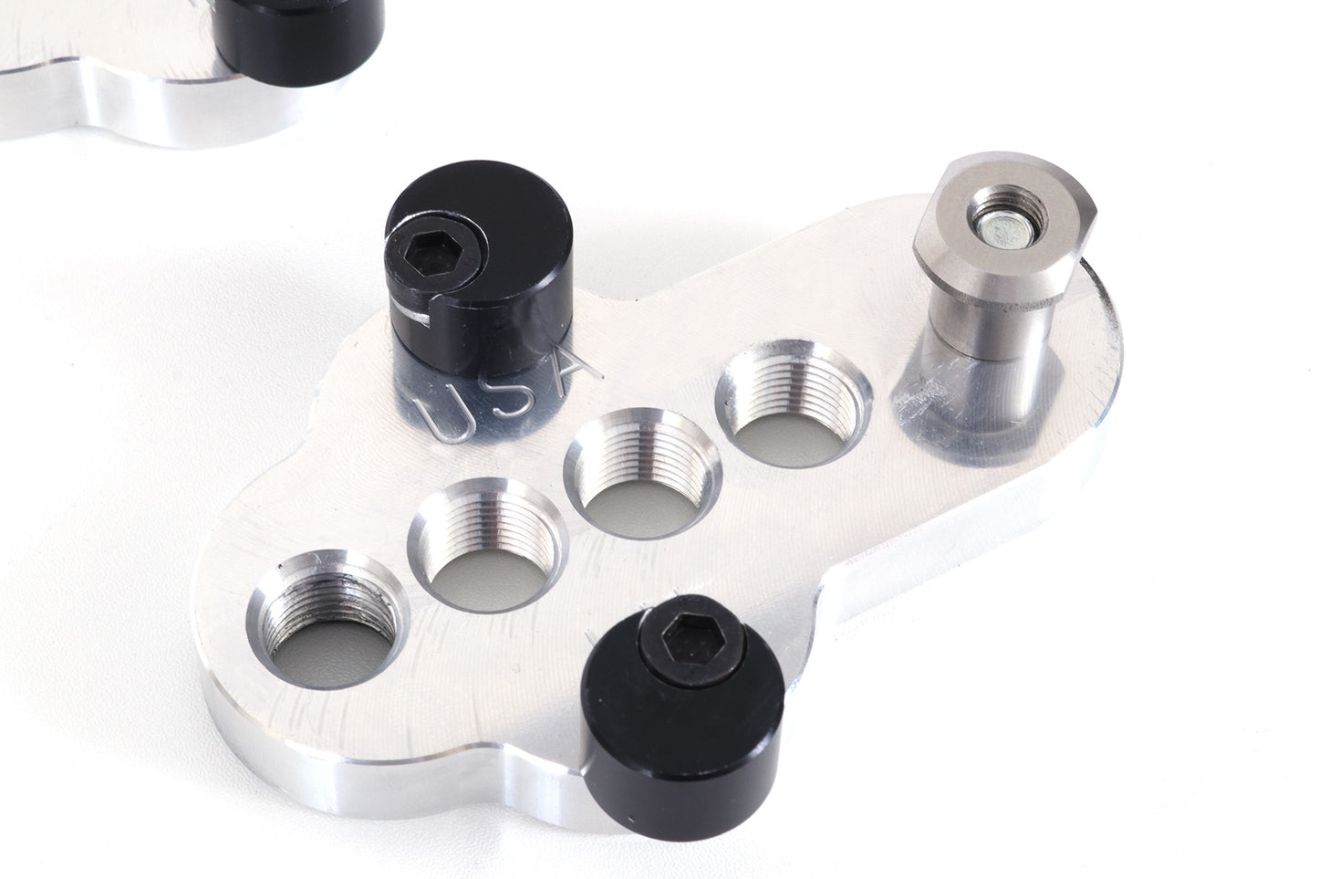 Closeup of a silver CJ Ackley Machine Company Wide Crank Arm Shortener.