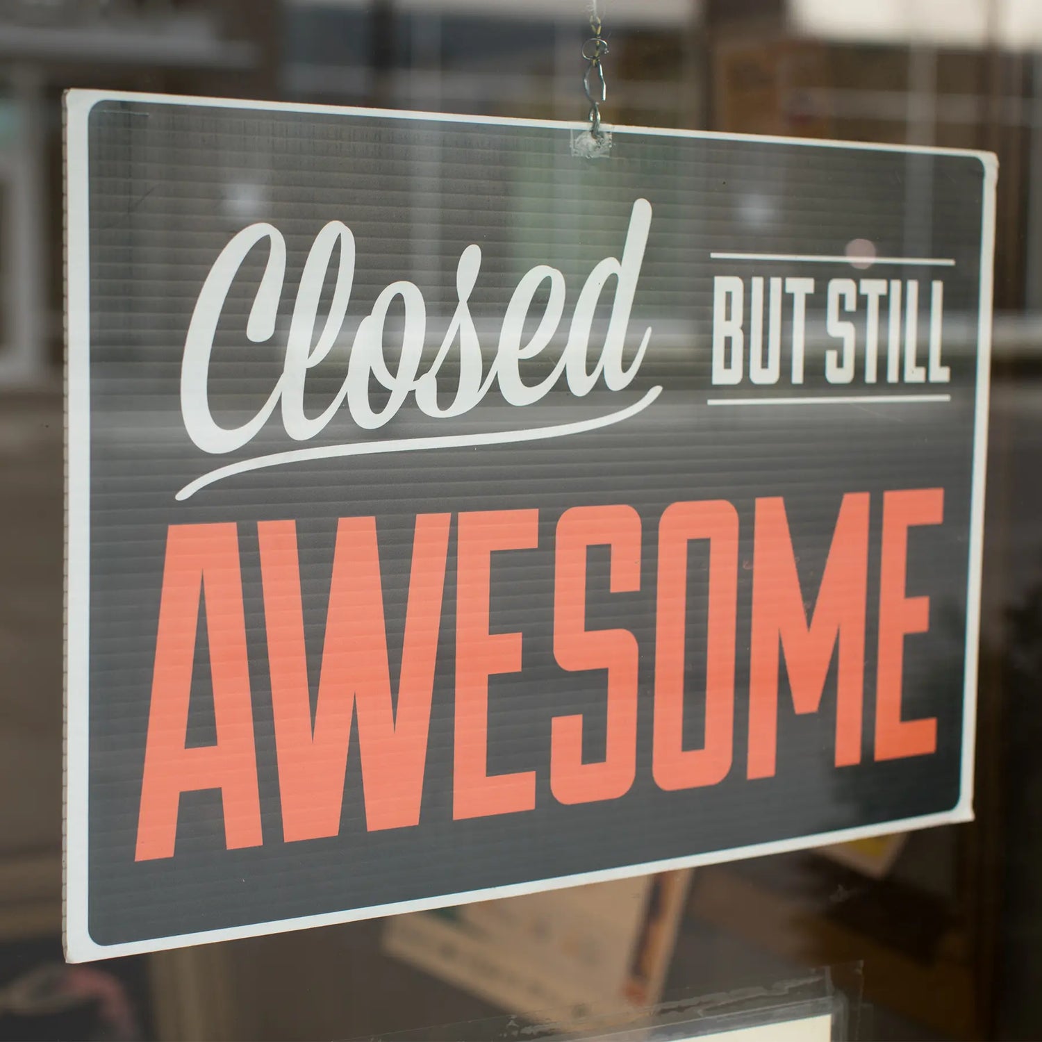 Image of a sign in the window that says "Closed but still awesome".