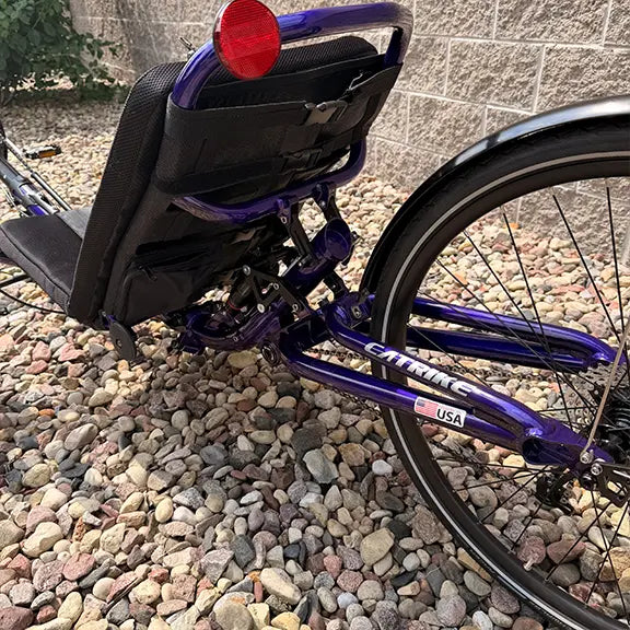 Closeup view of the back of the Catrike Demo Dumont Compact Candy Purple Recumbent Trike in an outdoor setting.