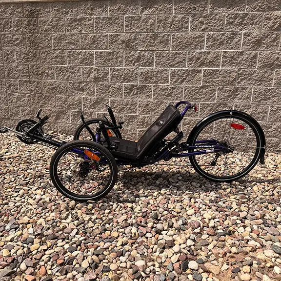 Non-drive side view of the Catrike Demo Dumont Compact Candy Purple Recumbent Trike in an outdoor setting.