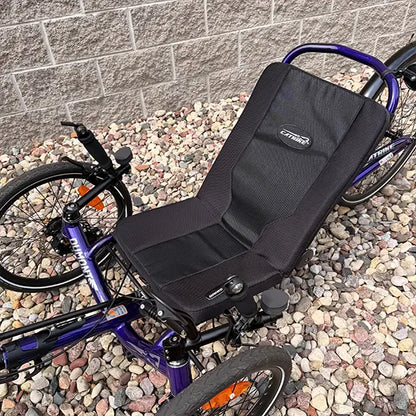 Closeup side view of the Catrike Demo Dumont Compact Candy Purple Recumbent Trike in an outdoor setting.
