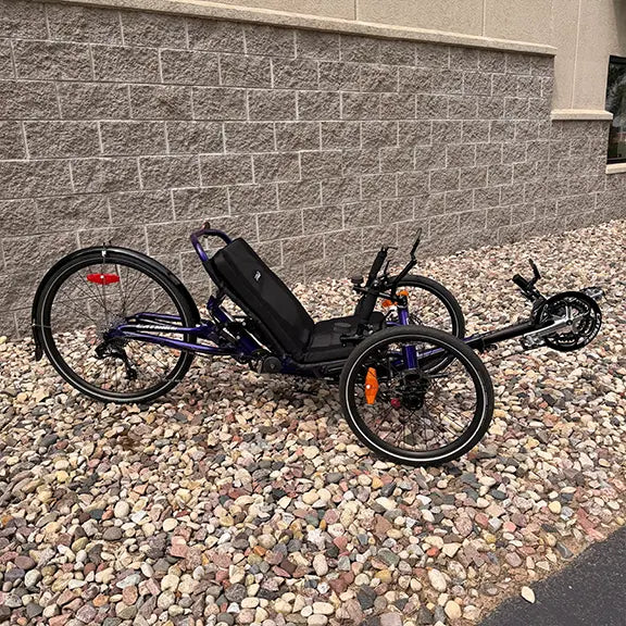 Side view of the Catrike Demo Dumont Compact Candy Purple Recumbent Trike in an outdoor setting.