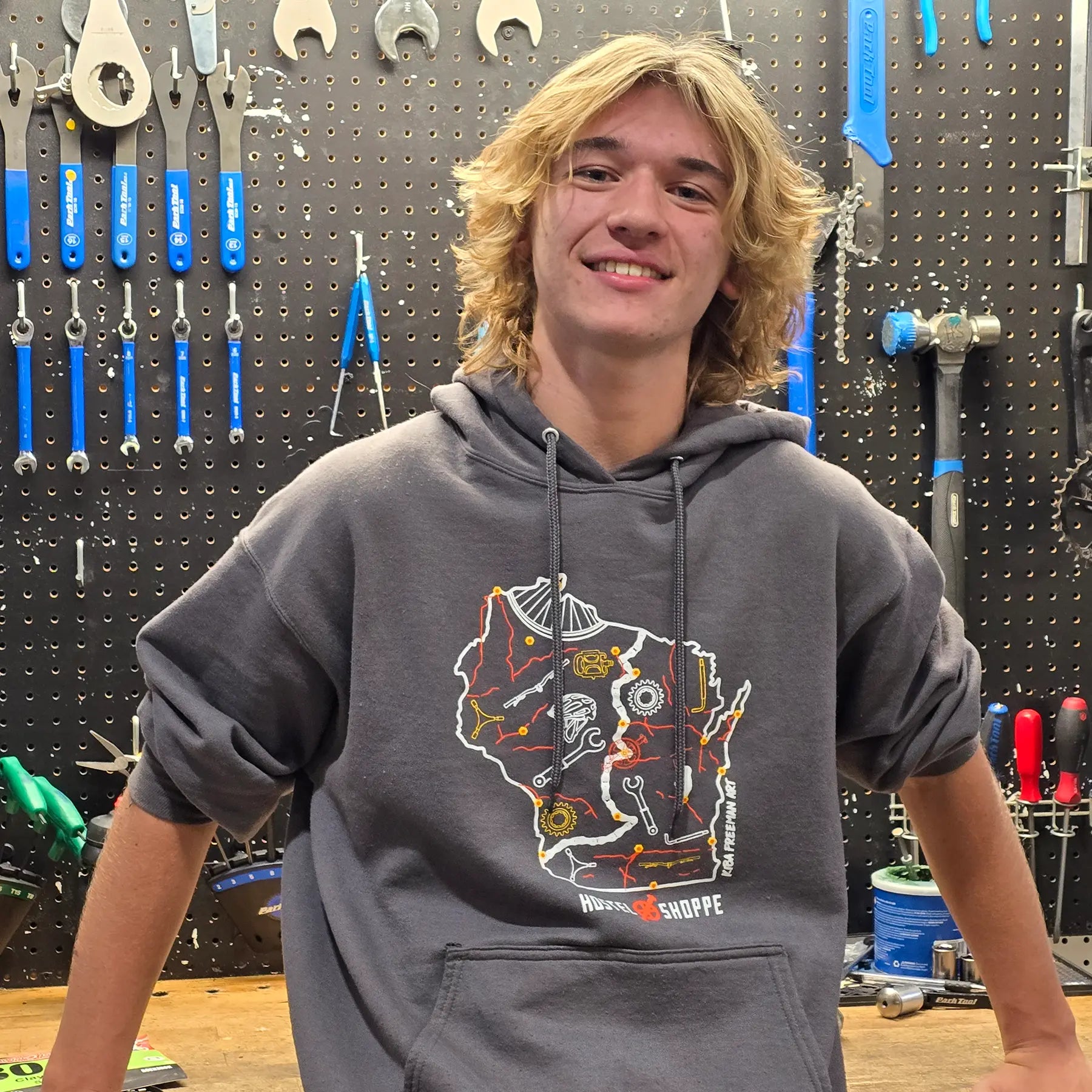 Eli, Mechanic, in front of his work bench and tool board.