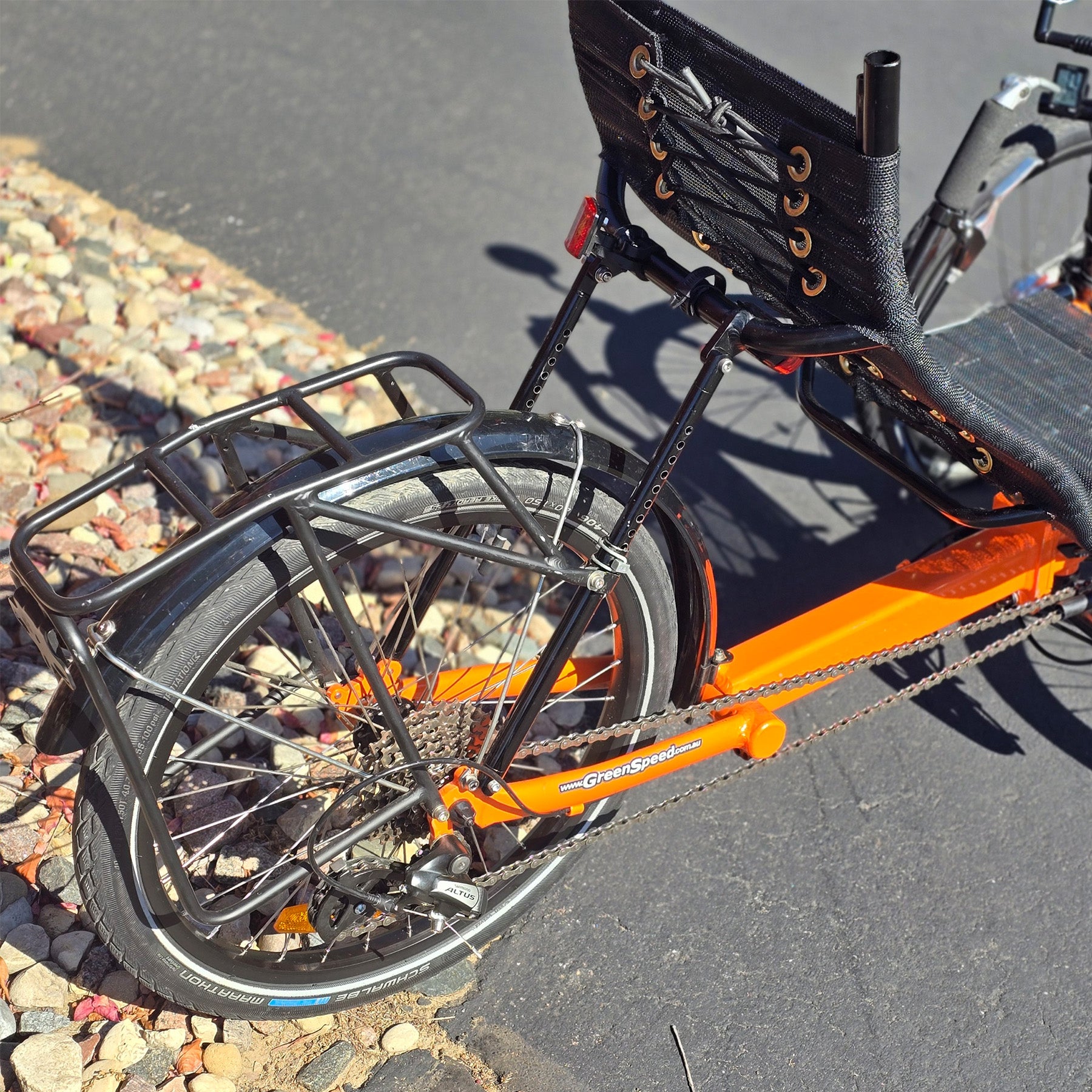 Rear closeup view of a used Greenspeed GT20 in orange in an outdoor setting.