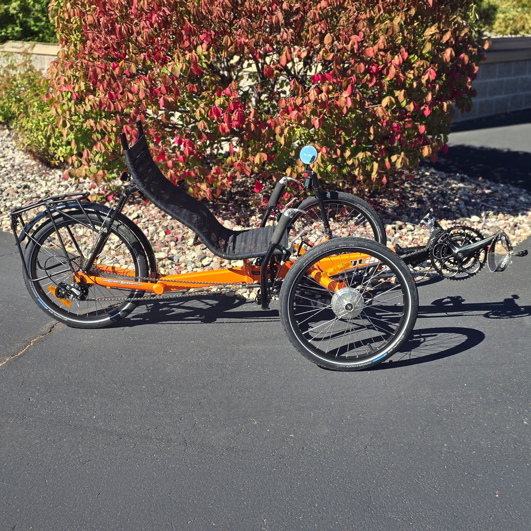 Side view of a used Greenspeed GT20 in orange in an outdoor setting.