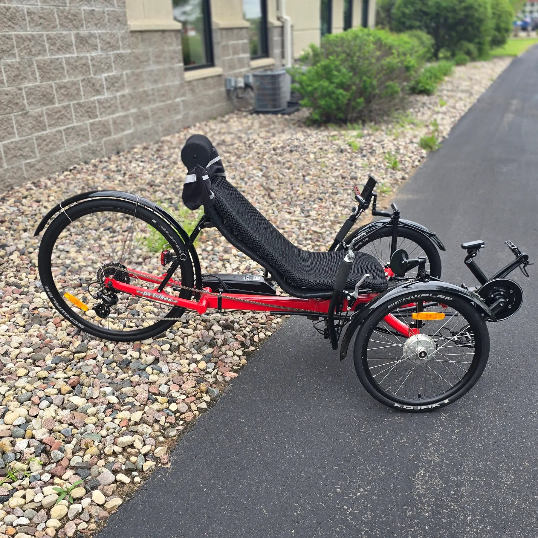 Side view of the Greenspeed Used GT26 with E.B.O. e-Assist Red Recumbent Trike in an outdoor setting.