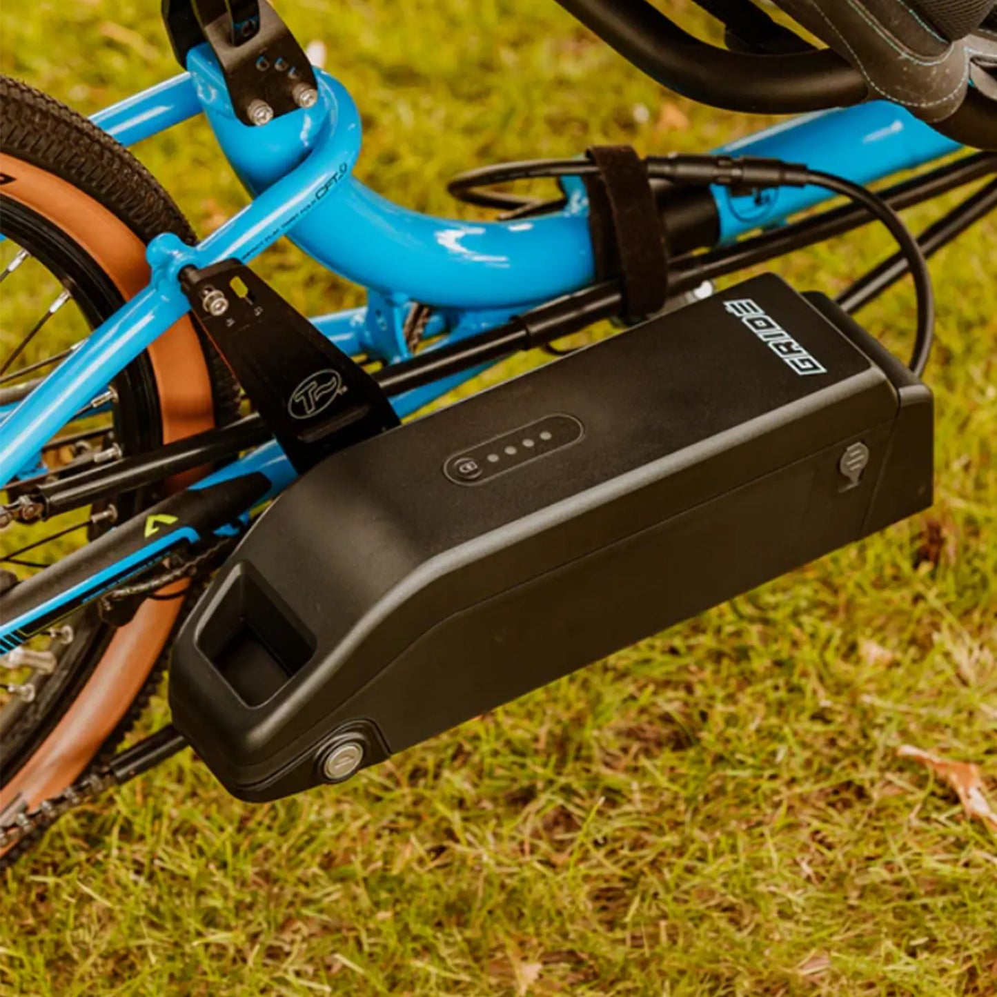Closeup view of the battery on the GRIDE Solutions GXT Plus E-Trike Drive System for 20 inch Rear Wheels mounted on a blue ICE trike in an outdoor setting.