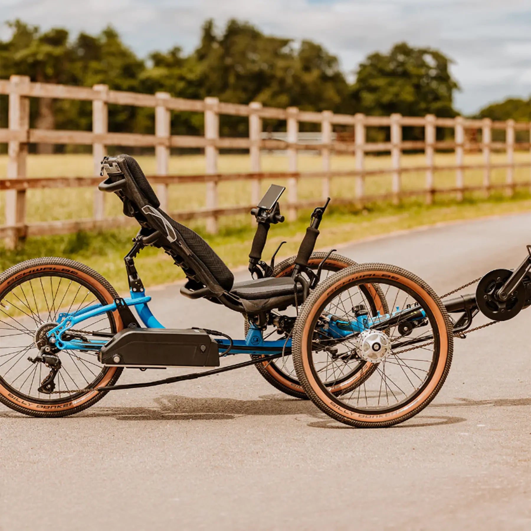 The GRIDE Solutions GXT Plus E-Trike Drive System for 20 inch Rear Wheels mounted on a blue ICE trike in an outdoor setting.