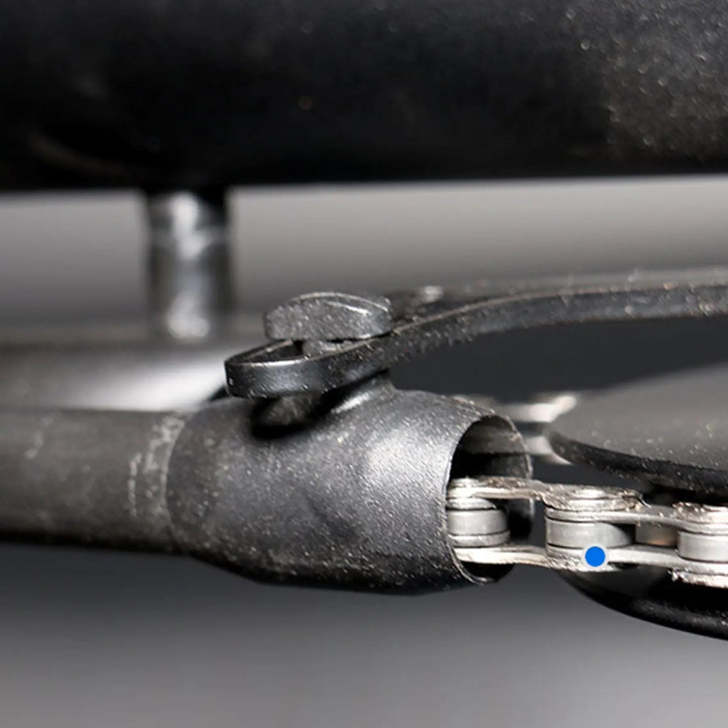 View of the black Hase Chain Tube Plastic Bracket Full Tube installed on a supporting bracket on a Hase Trike. background.