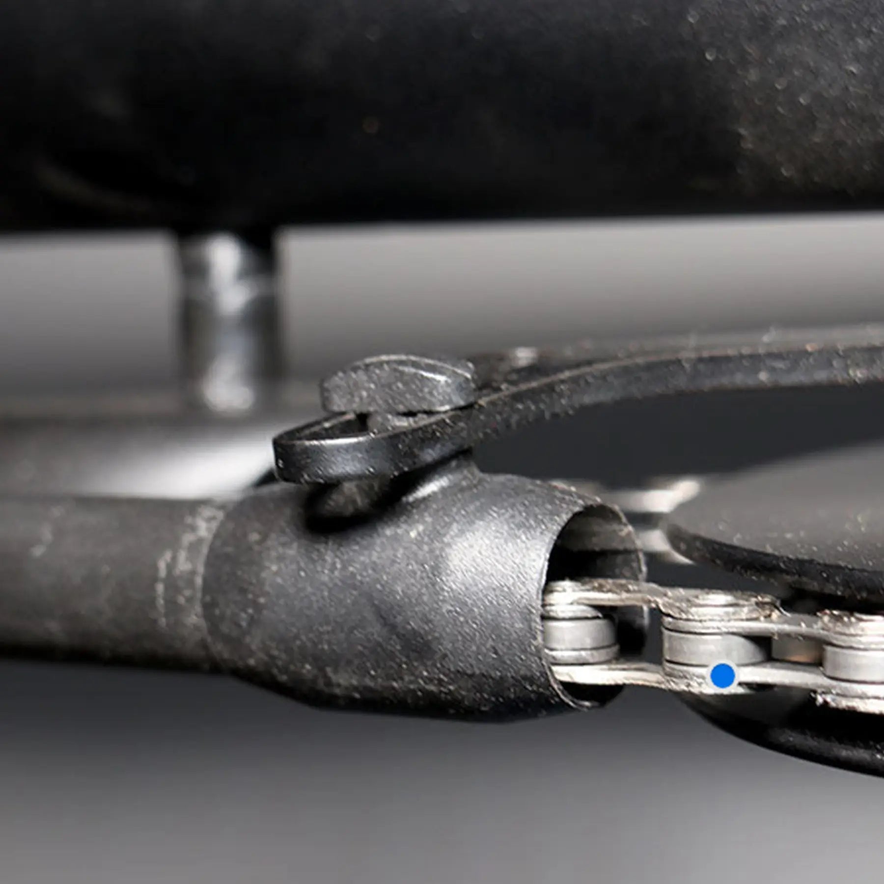View of the black Hase Chain Tube Plastic Bracket Full Tube installed on a supporting bracket on a Hase Trike. background.