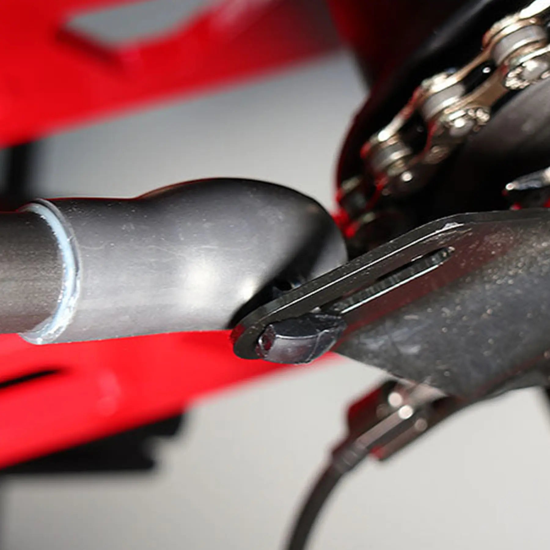 View of the black Hase Chain Tube Plastic Bracket Full Tube installed on a supporting bracket on a Hase Trike. 