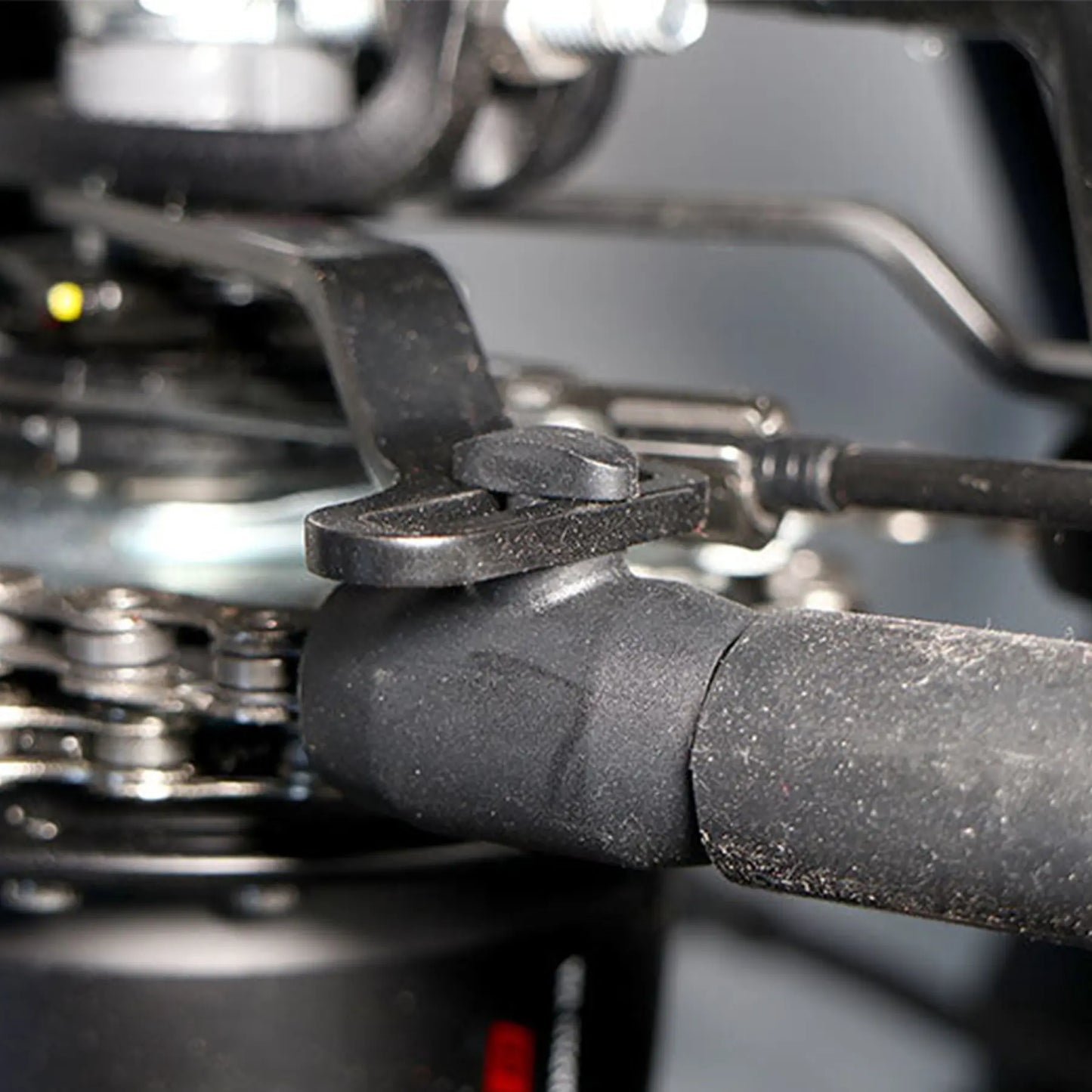 View of the black Hase Chain Tube Plastic Bracket Full Tube installed on a supporting bracket on a Hase Trike. 