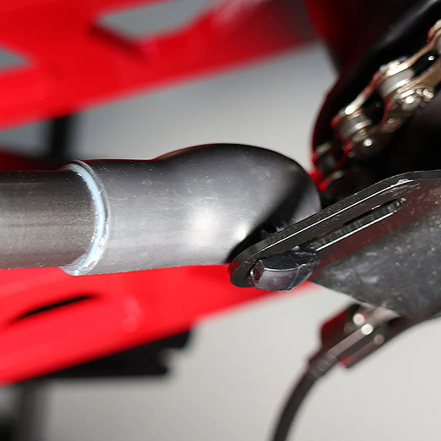 Closeup view of the black Hase Heat Shrink for Chain Tube Bracket securing a Hase Chain Tube Plastic Bracket on a trike.