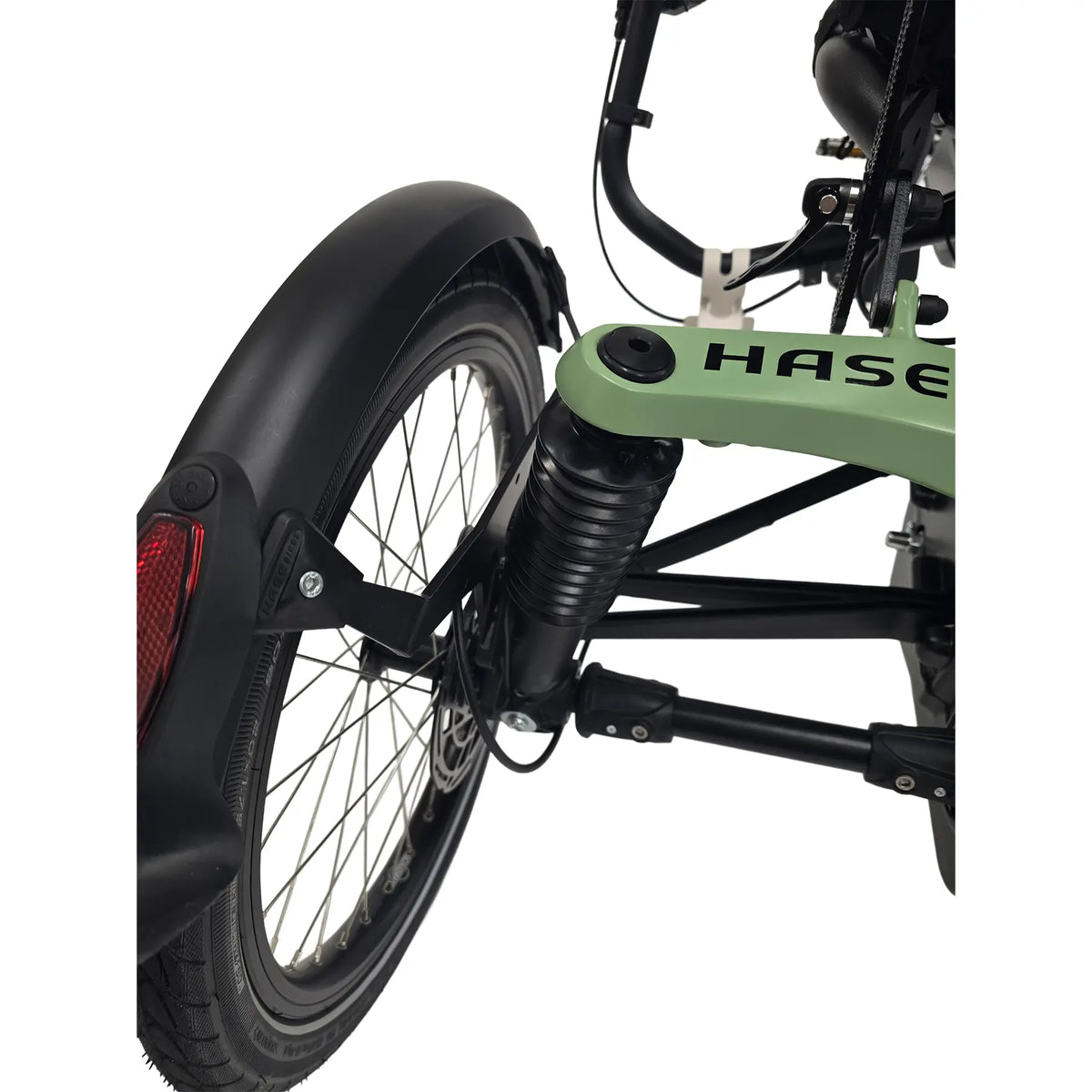 Closeup view of the rear suspension and wheel on the Hase Kettwiesel One Plus Enviolo Bosch Performance CX Pale Green Recumbent Trike against a white background.
