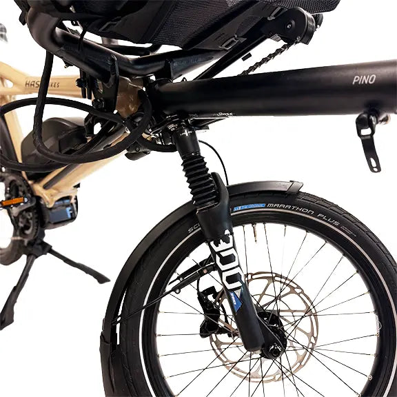 Closeup view of the front suspension fork and frame on the Hase Pino EP6 Cargo Grey Beige Tandem Recumbent Bike against a white background.